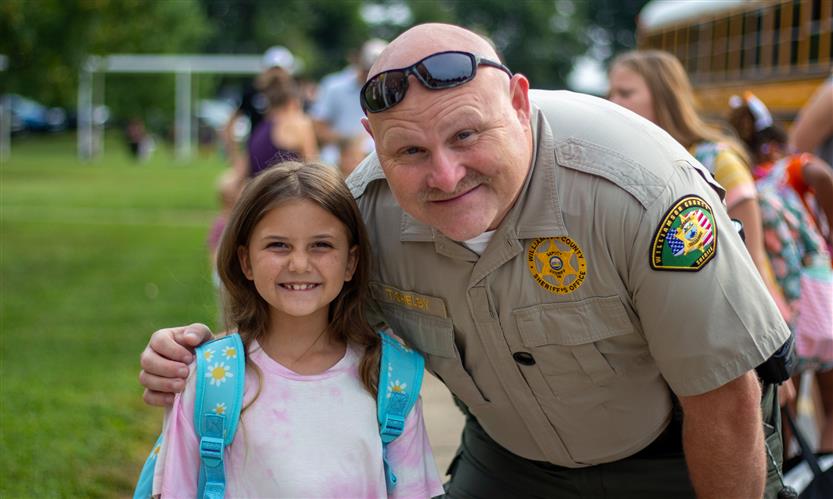 A student and school resource officer smile
